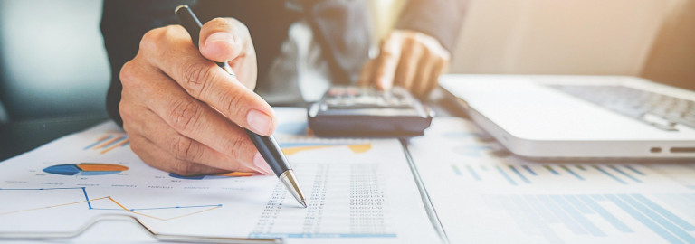 Mensch mit Stift und Finanzplänen