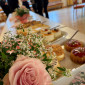 Tisch mit Rosenstrauß und Törtchen gedeckt