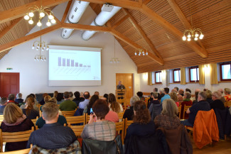 Synodale sitzen im Gemeindezentrum und hören einen Vortrag